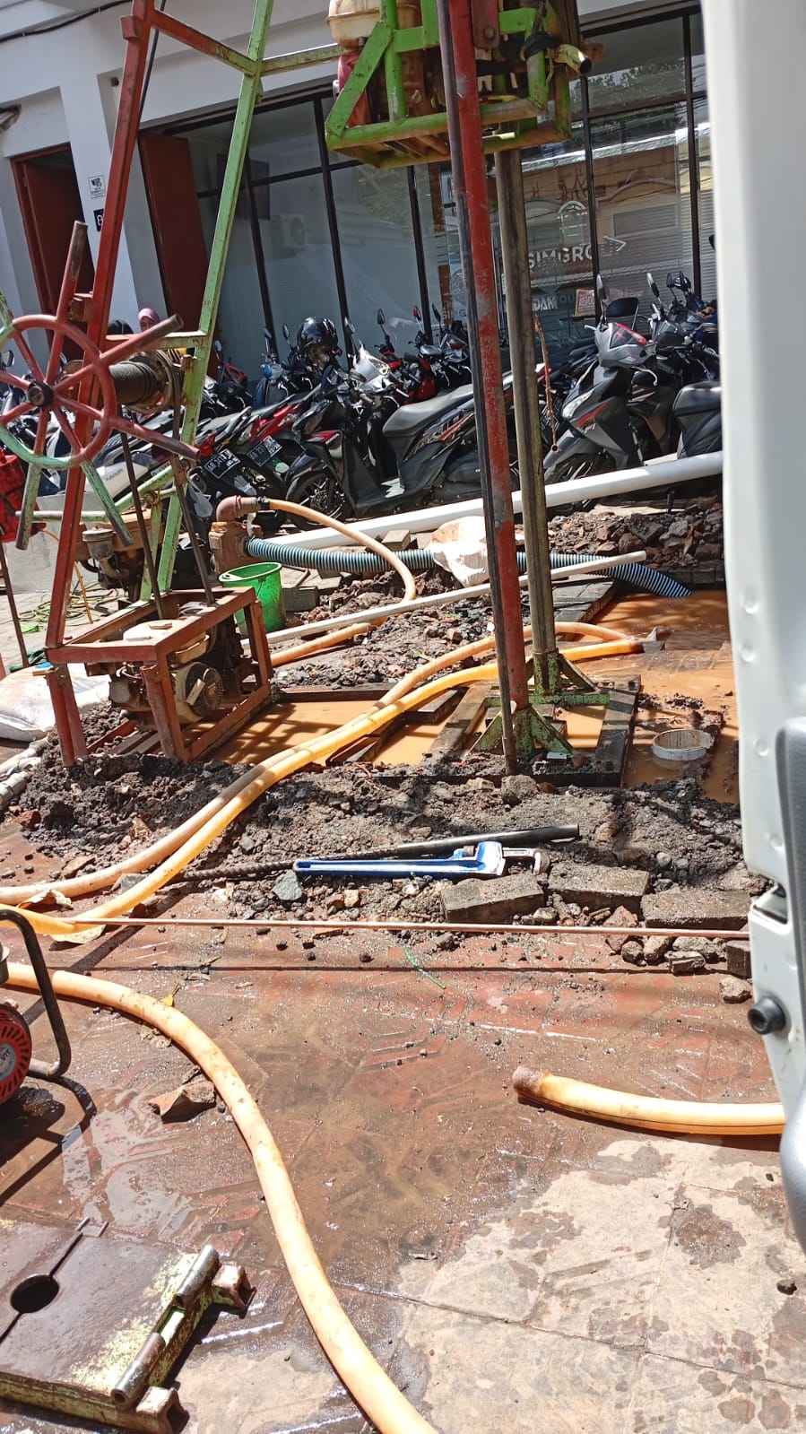 Area proyek komersial dengan rig bor dan selang oranye